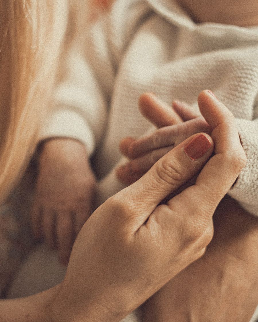 La main d’un bébé tenue dans celle de sa mère